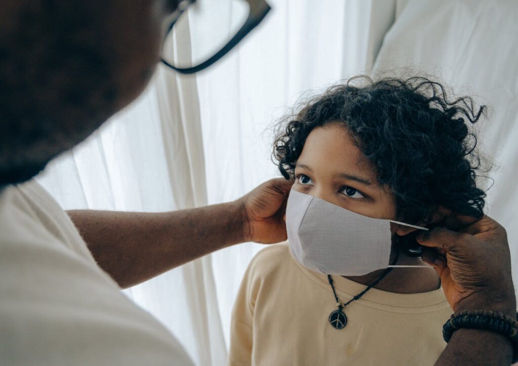 pexels-photo-4546132 From above unrecognizable black man wearing protective mask on face of ethnic kid standing in room near window closed with curtain